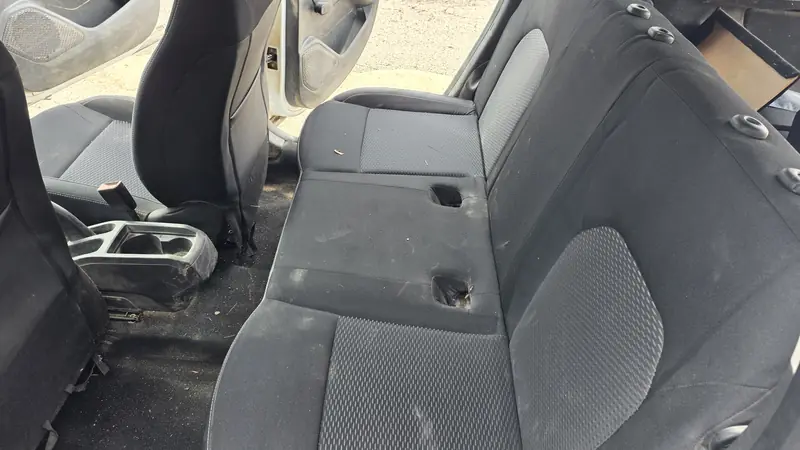 Banquette arrière d'une Dacia très sale, avant le nettoyage